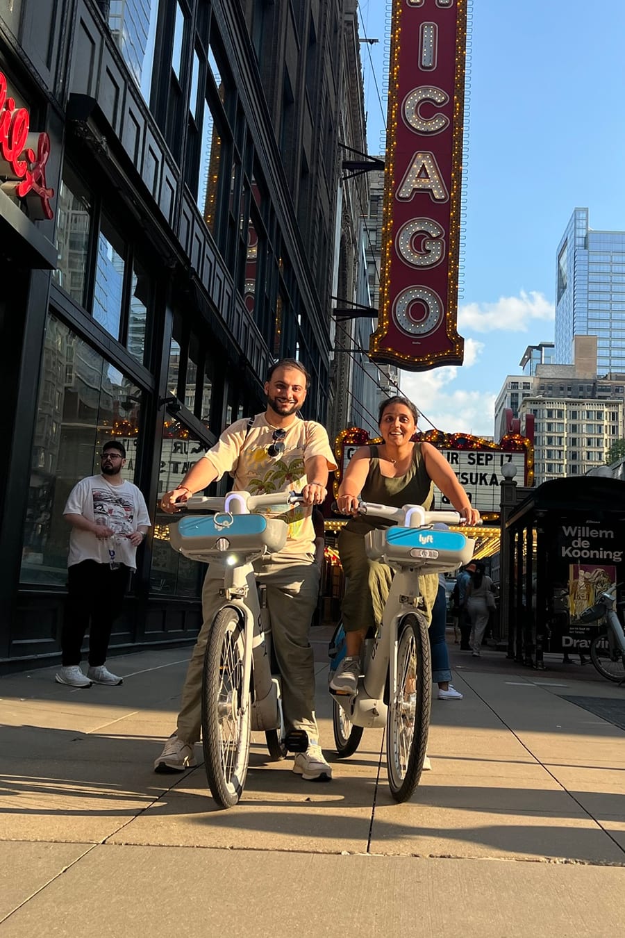 Meet and Preksha biking under the Chicago Theatre sign